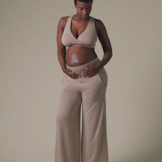 Video of pregnant model wearing French Terry Racerback Nursing & Sleep Bra in Sandstone and Bamboo Wide Leg Maternity & Postpartum Lounge Pant in Sandstone on a beige background.