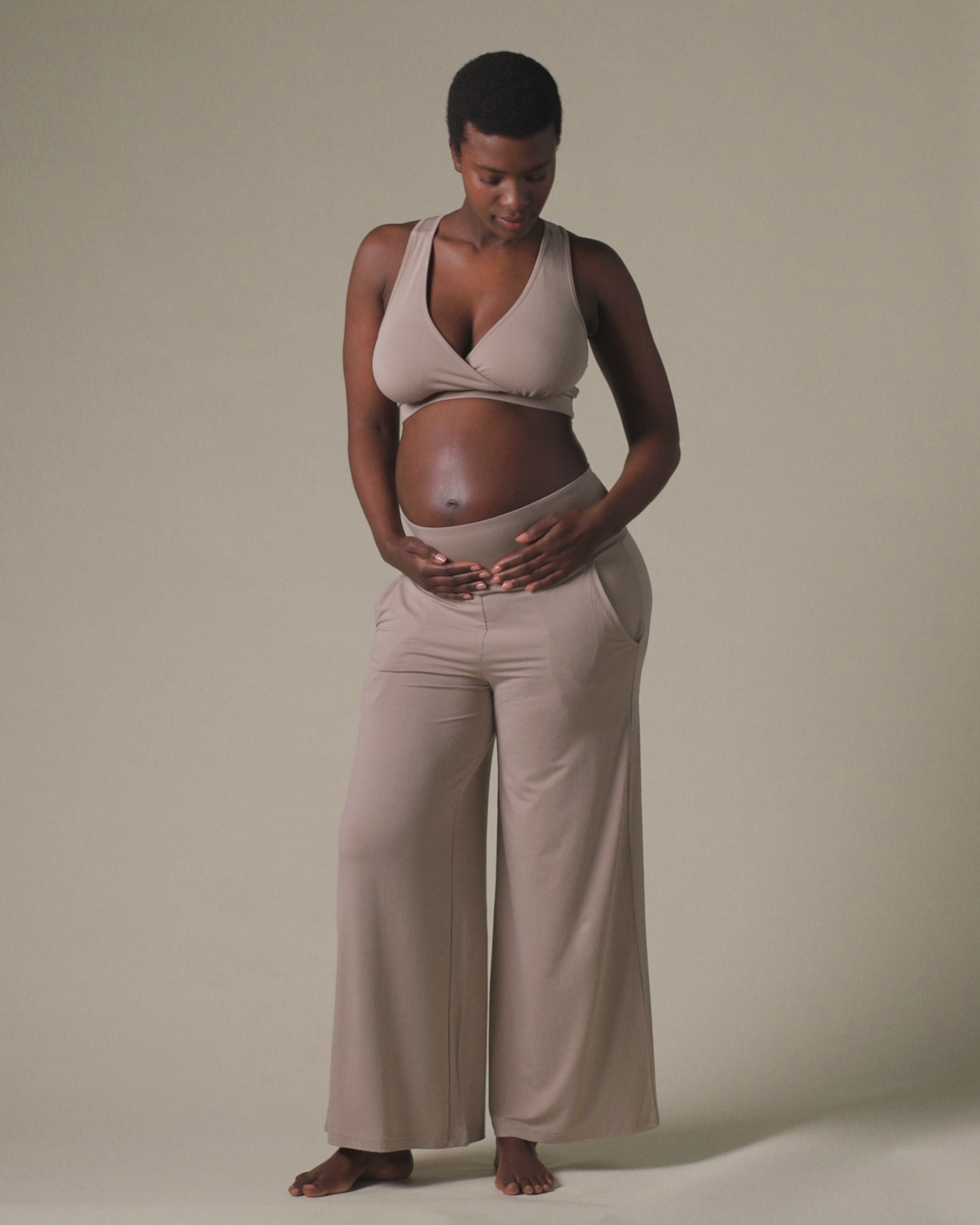 Video of pregnant model wearing French Terry Racerback Nursing & Sleep Bra in Sandstone and Bamboo Wide Leg Maternity & Postpartum Lounge Pant in Sandstone on a beige background.