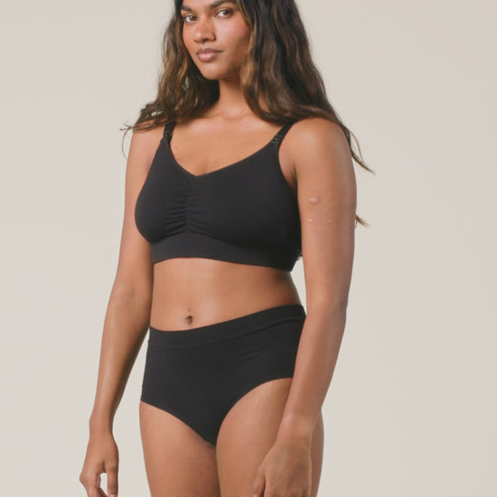 Video of model showing the fit on Every Stage Brief in Black and Every Stage Pumping & Nursing Bra in Black on a beige background