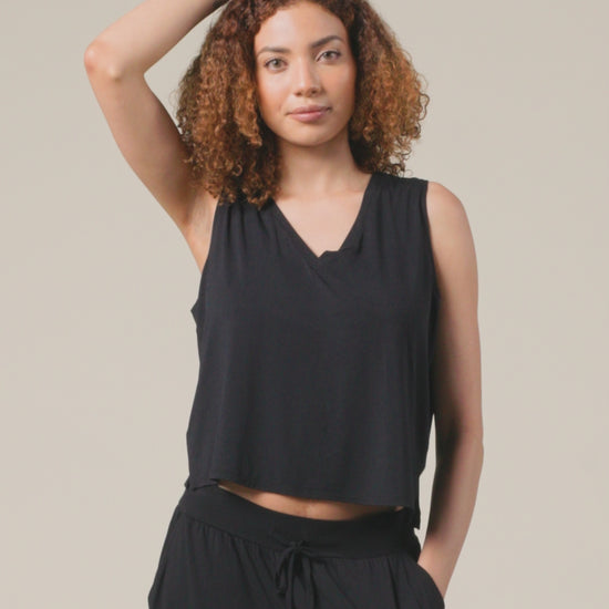 Video of model showing fit on Aria Bamboo Cropped V-neck Tank in Black and Aria Bamboo Casual Lounge Pant in Black on a beige background.