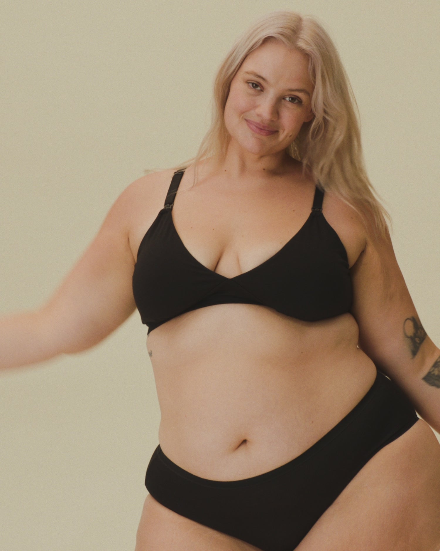 Video of Model showing the fit on SoftStretch Cotton Nursing Bra in Black and SoftStretch Cotton Maternity & Postpartum Hipster in Black on a beige background.