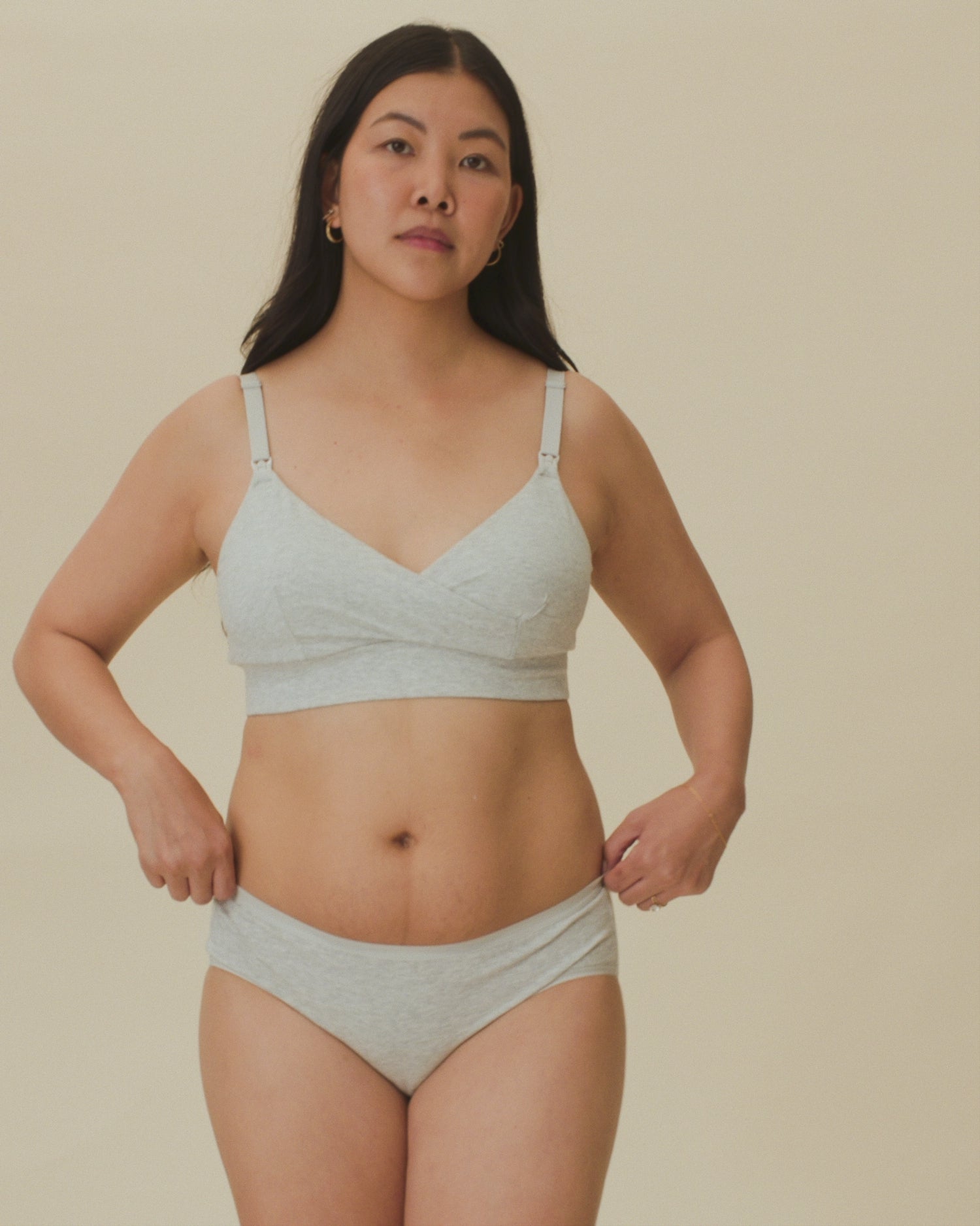 Video of model showing the soft fit of  SoftStretch Cotton Nursing Bra and SoftStretch Cotton Maternity & Postpartum Hipster in Grey Heather on a beige background. 