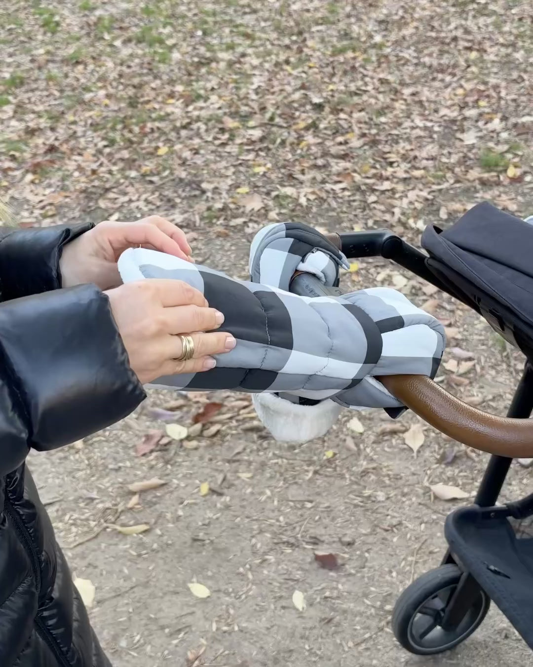 Model prepares the Cozy Stroller Mitts in Buffalo Plaid for her winter stroller party in the park with baby. As she rolls them open, you can see the fuzzy soft interior just before she pops both hands in, ready to push the stroller in complete comfort.
