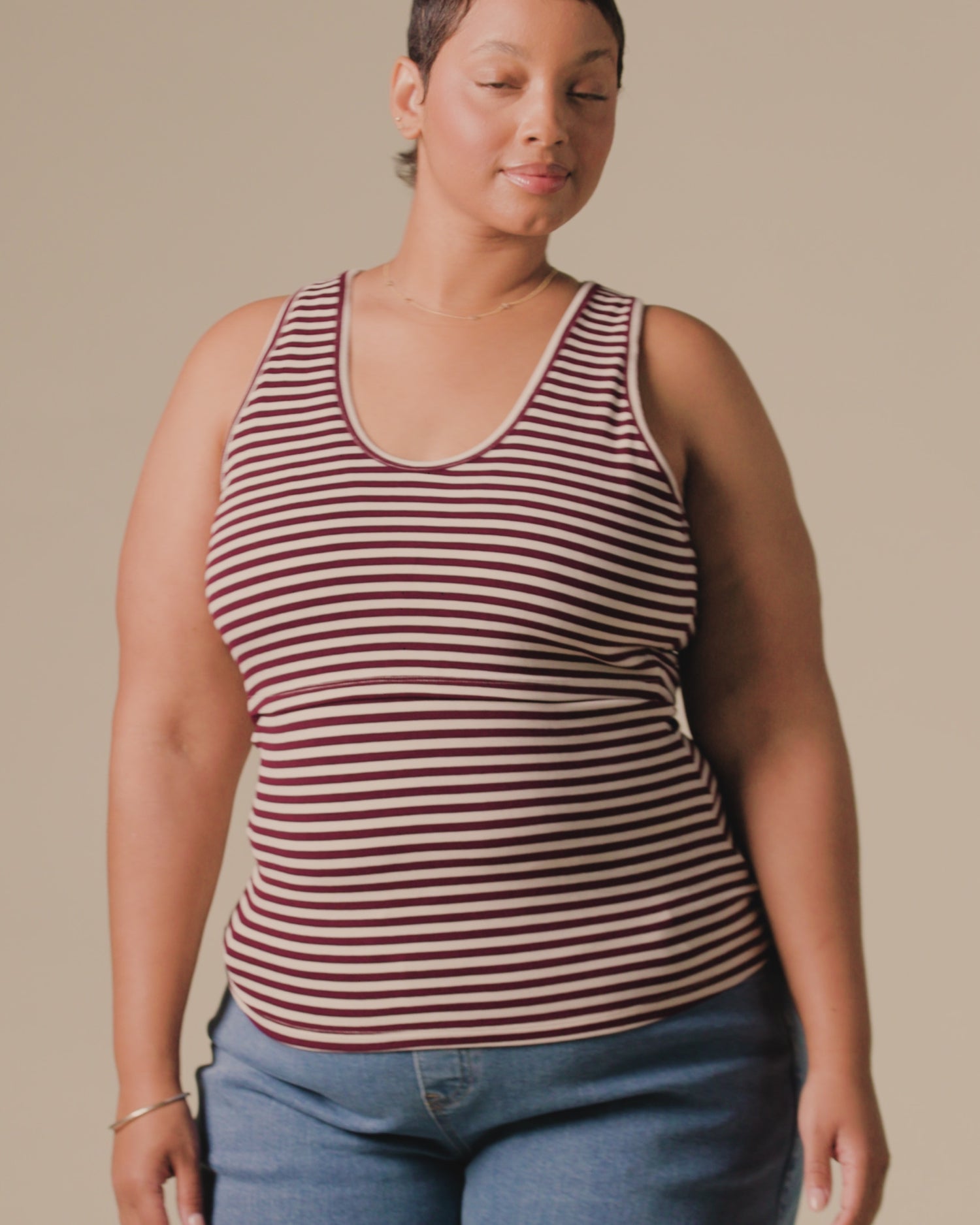 Video of model wearing Ribbed Bamboo Scoop Neck Nursing Tank in Garnet Stripe on a beige background.
