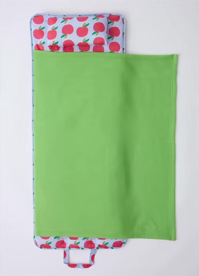 Stop motion video of the Cool Kid Nap Mat in Blue Apple folding up into an easy to carry pack, on a beige background.