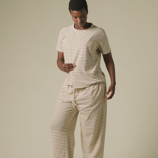 Video of model wearing Luxe Terry Maternity & Nursing Split Hem T-shirt in Ivory & Chocolate Stripe and Luxe Terry Maternity & Postpartum Pant in Ivory & Chocolate Stripe, on a beige background.