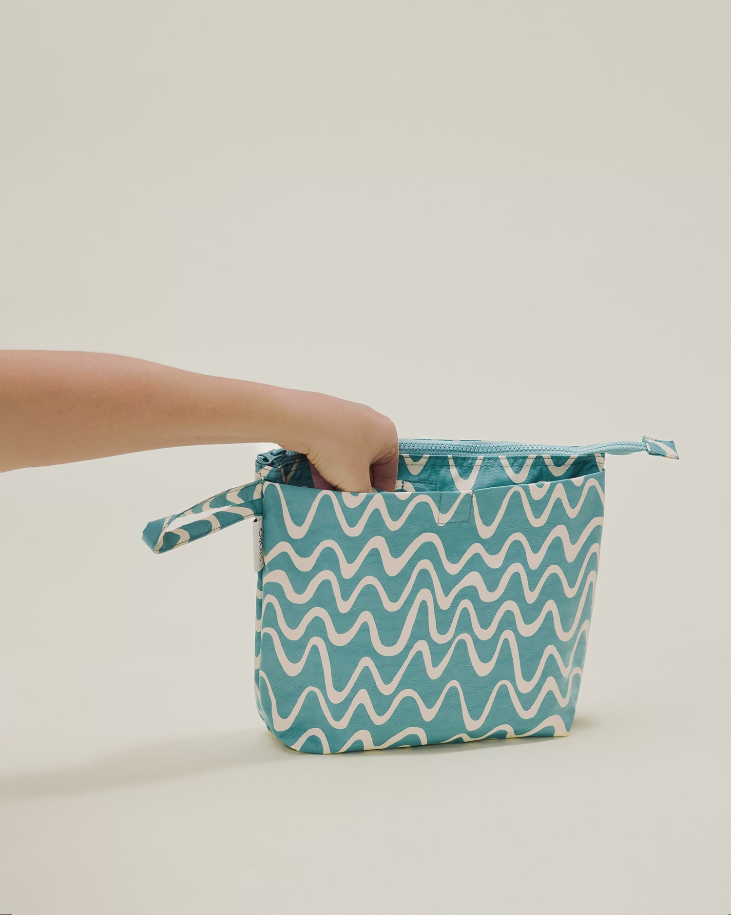 Stop motion video showing a hand putting in and out the changing pad included in the Quick Change Kit Bag in Waves