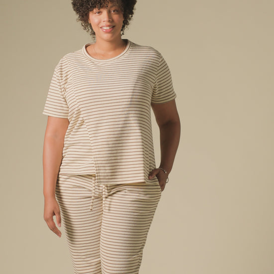 Video of model wearing Luxe Terry Maternity & Nursing Split Hem T-shirt in Ivory & Chocolate Stripe and Luxe Terry Maternity & Postpartum Pant in Ivory & Chocolate Stripe, on a beige background.