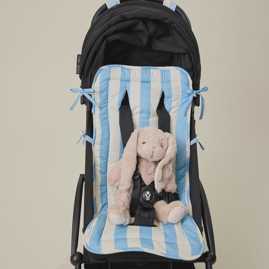 Video for the Stroller Party Set with Seat Liner, Party Clips and Caddy Bag in Blue Wide Stripe with small bunny doll buckled into stroller, on a beige background