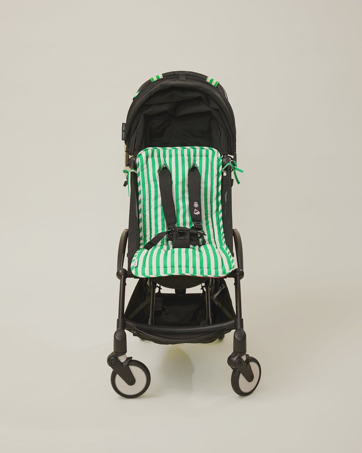 Stop motion video showing a stroller with the Stroller Party Seat Liner, Stroller Party Clips and Stroller Party Caddy Bag in Green Stripe