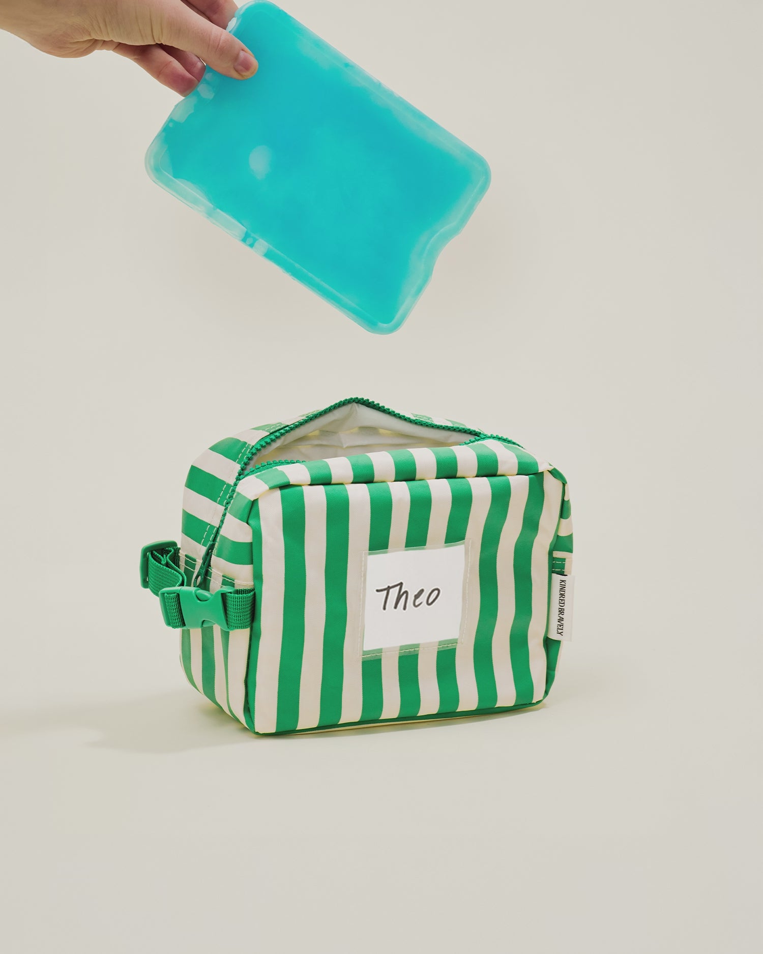 Stop motion video showing a cooler pad and milk being placed inside the Mini Cooler Bag in Green Stripe