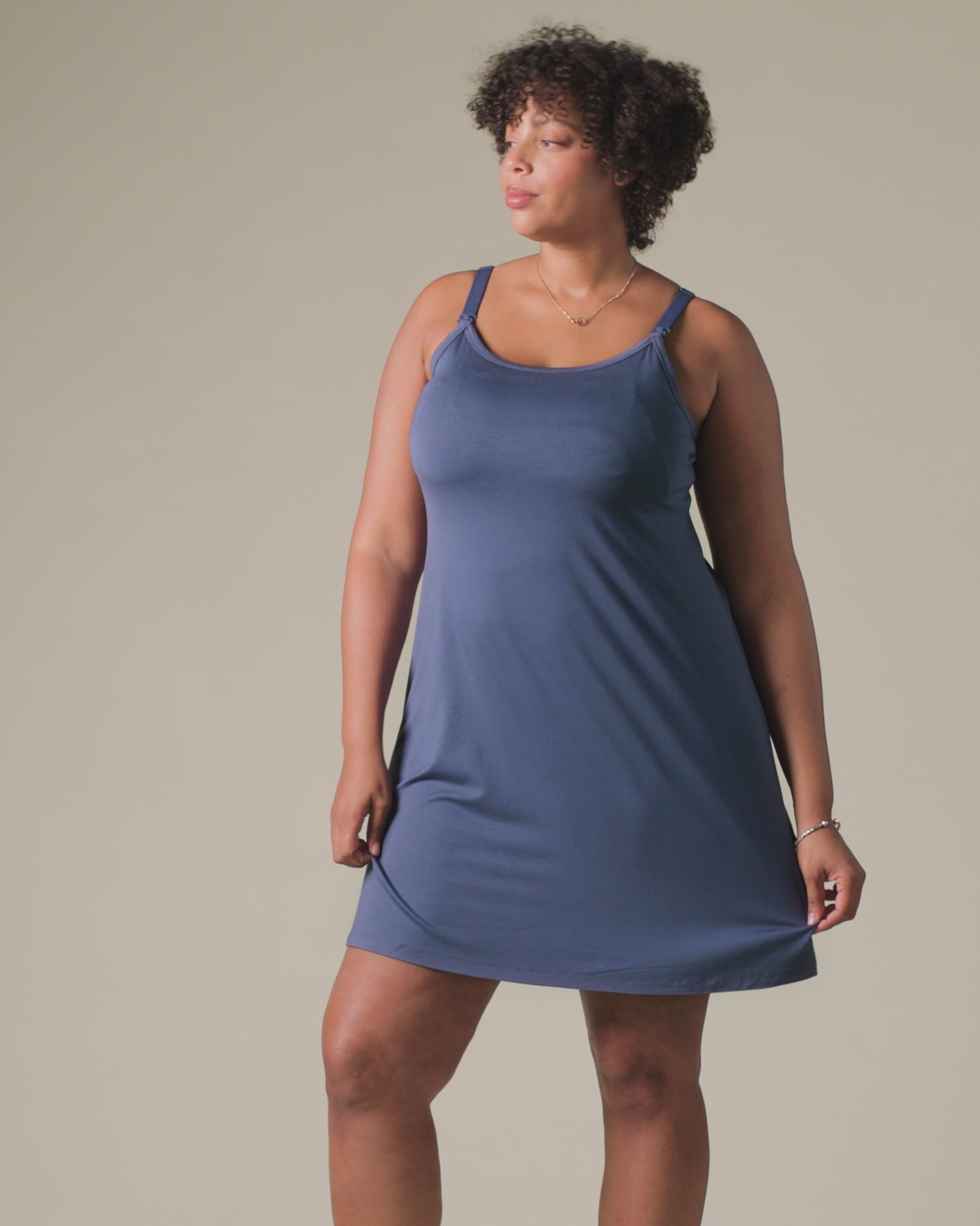 Video of model wearing Stella Hands-Free Pumping & Nursing Nightgown in Slate Blue, on a beige background.