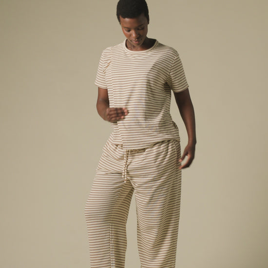 Video of model wearing Luxe Terry Maternity & Nursing Split Hem T-shirt in Ivory & Chocolate Stripe and Luxe Terry Maternity & Postpartum Pant in Ivory & Chocolate Stripe, on a beige background.