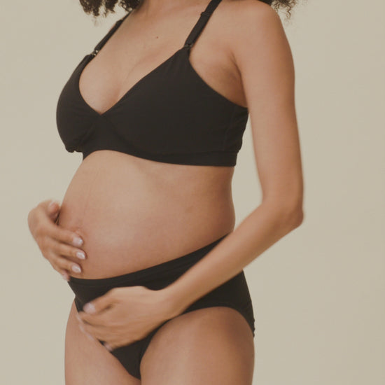 Video of model showing the soft fit of the SoftStretch Cotton Maternity & Nursing Bralette in Black and SoftStretch Cotton Maternity & Postpartum Brief in Black on a beige background.