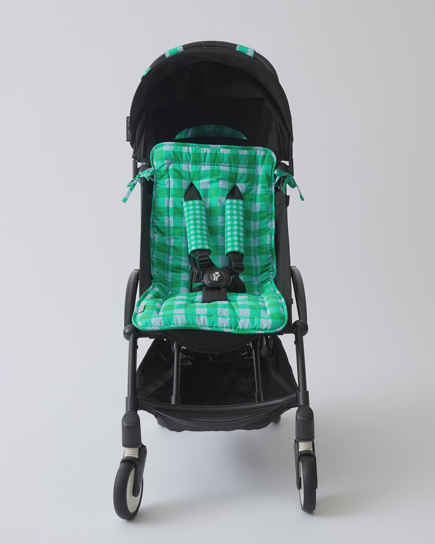 Video of black stroller with Stroller Party™ Seat Liner & Strap Covers, Clips, and Caddy Bag in Teal Gingham on a beige background.