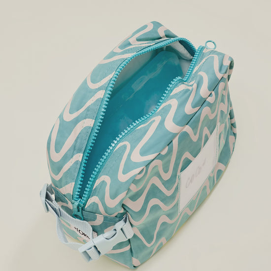 Stop motion video showing the inside of the Mini Cooler Bag in color Waves, with a cooler ice pack and snacks placed inside