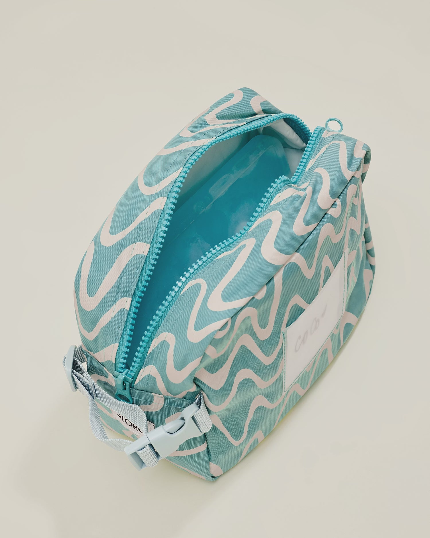 Stop motion video showing the inside of the Mini Cooler Bag in color Waves, with a cooler ice pack and snacks placed inside