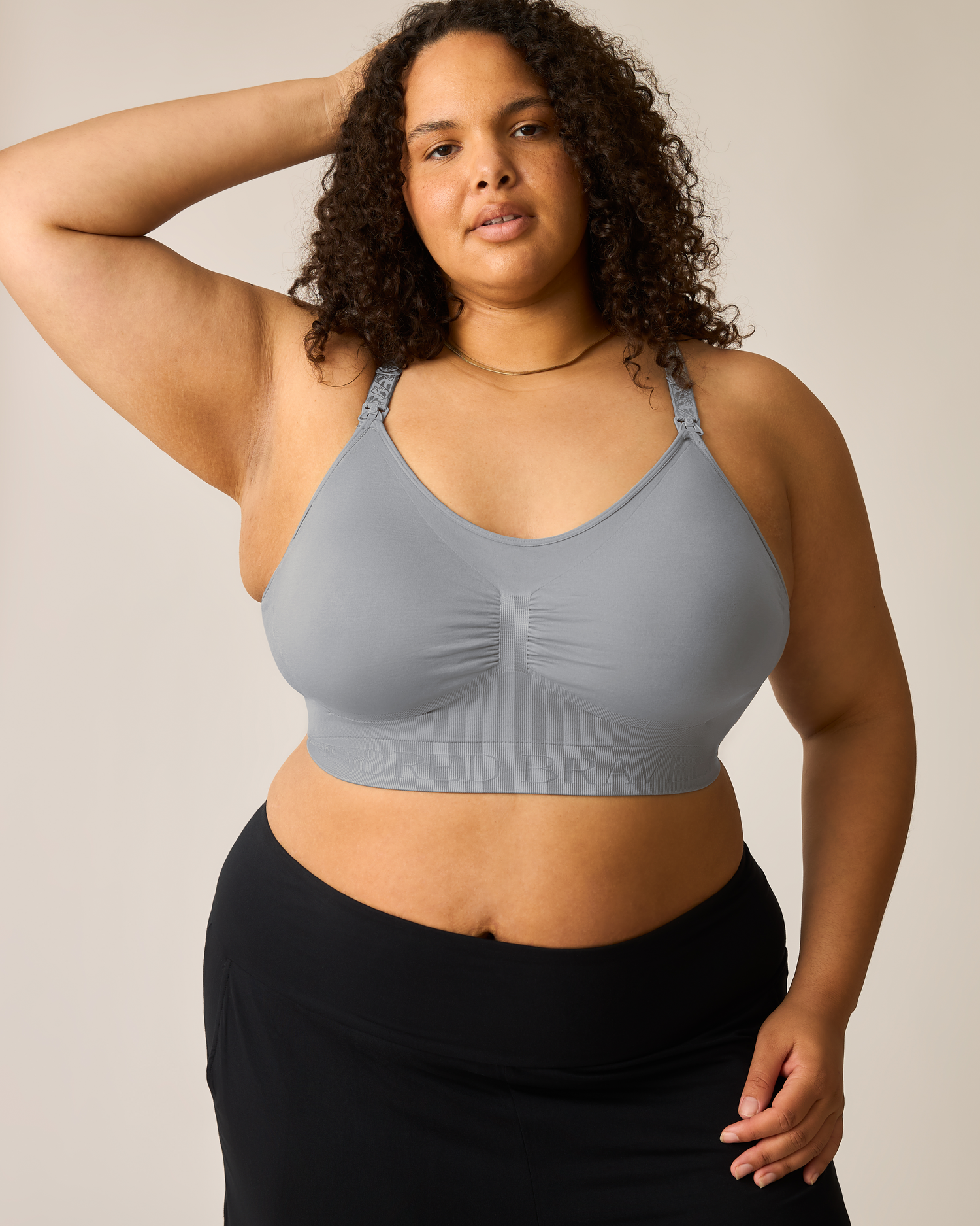 Woman wearing a gray bra with a neutral background