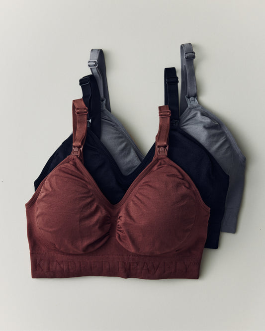 Wash Wear Spare® Sublime® Nursing Bra Bundle in Black, Redwood and Grey on a beige background.