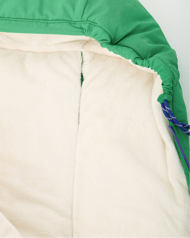 Close up of hood lining and fuzzy interior of the Cozy Stroller Footmuff in Green on an off white background.